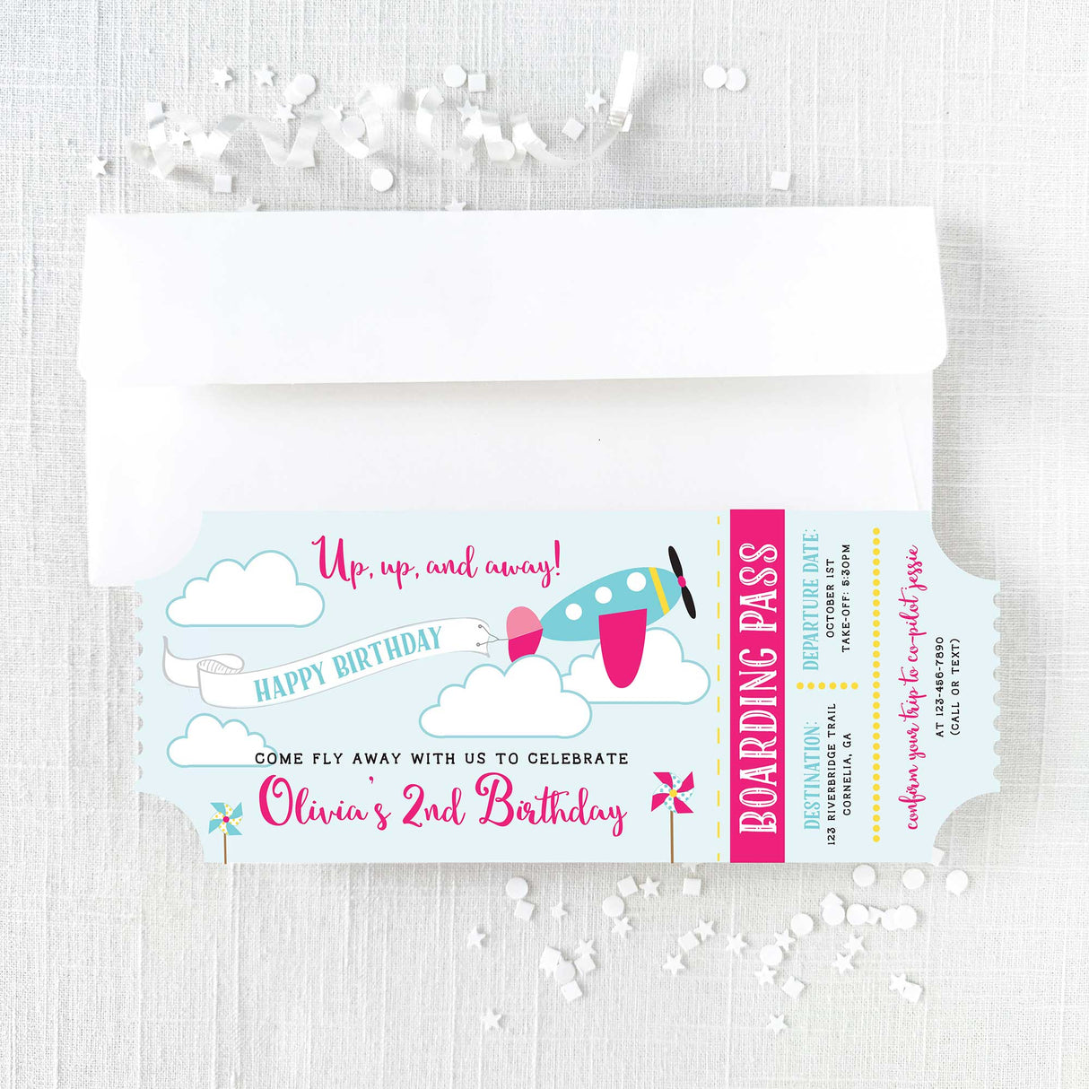 pink ticket invitation with airplane design and white envelope