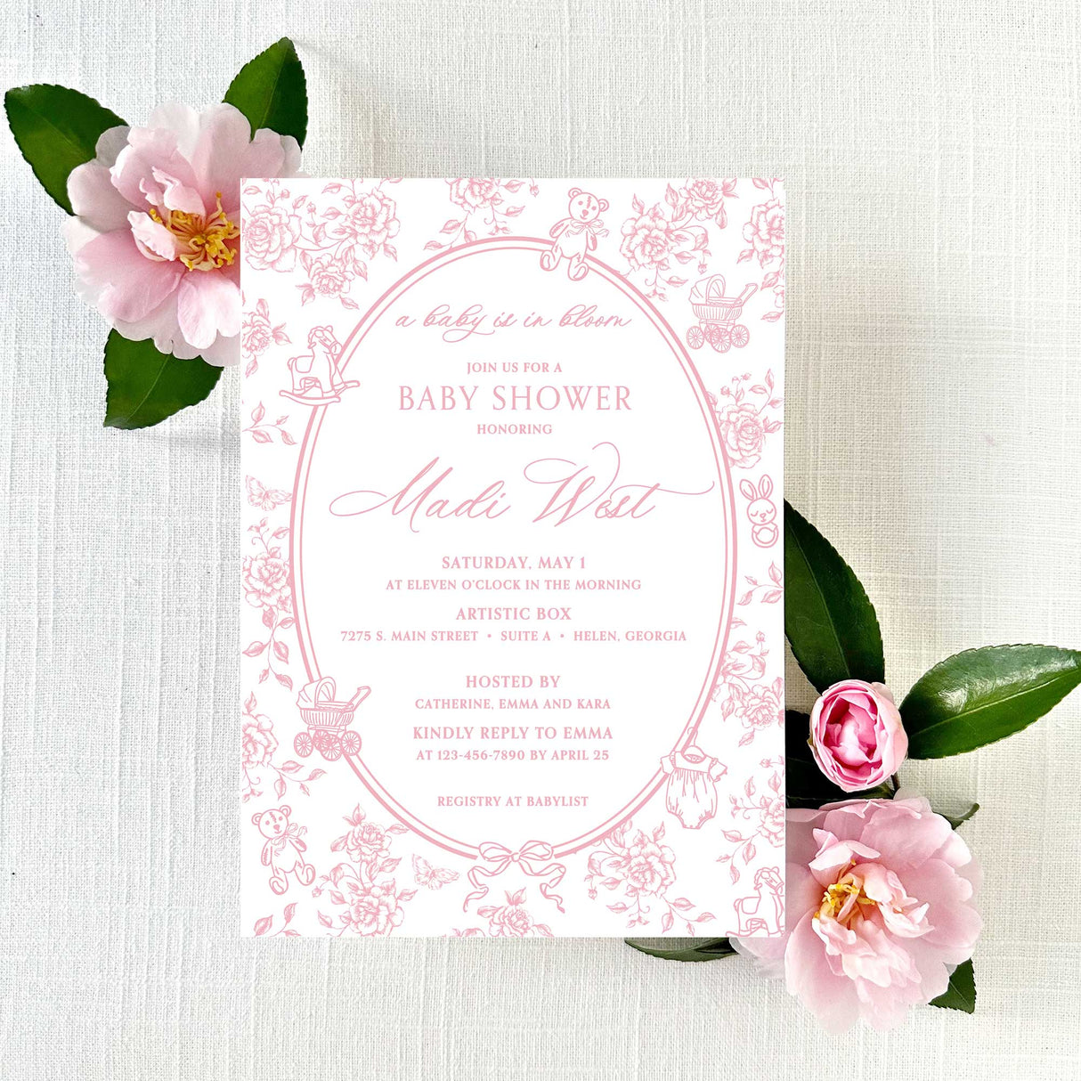 A pink baby shower invitation with floral pattern background, including roses and vintage baby designs