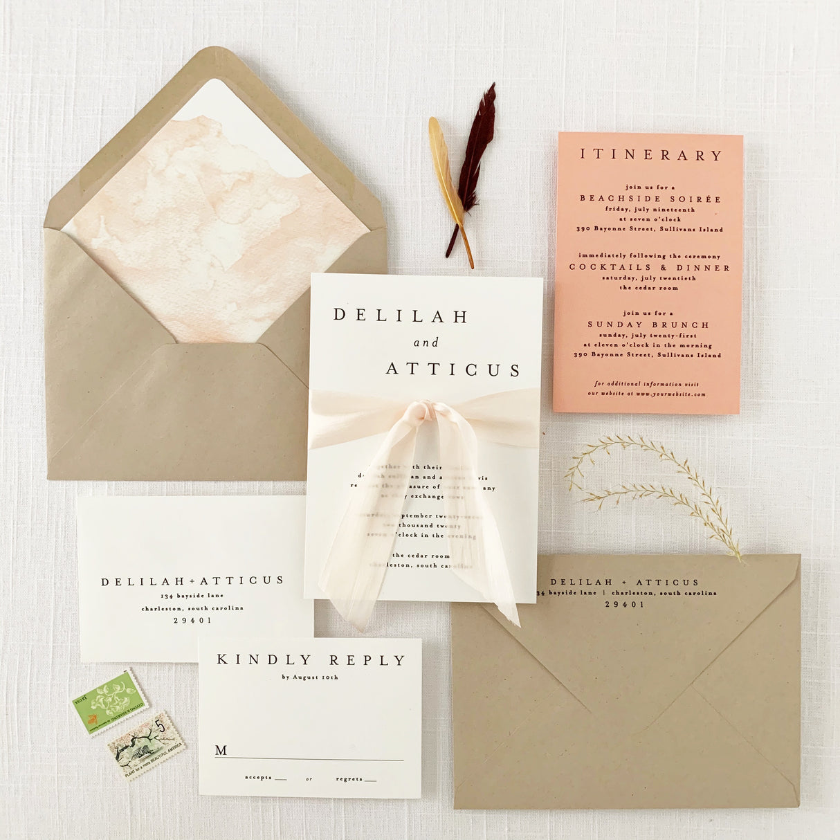 A set of modern boho wedding invitations with envelopes, an RSVP card, and a silk ribbon embellishment, featuring a peach-colored watercolor liner and natural khaki envelopes.