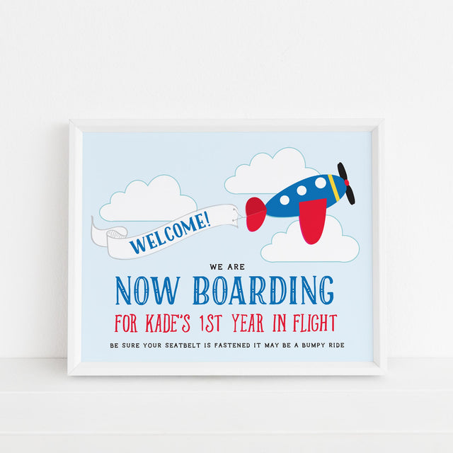 welcome sign with blue and red airplane design and now boarding text printed on white cardstock
