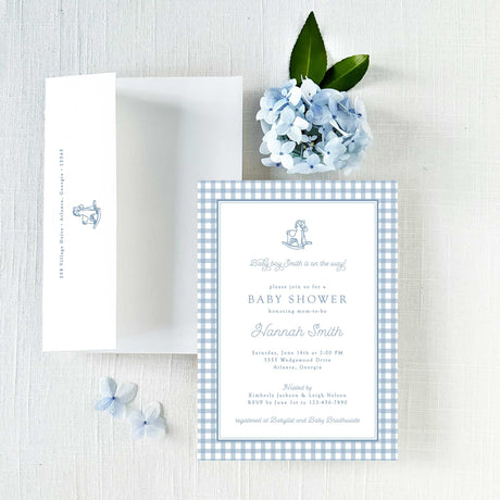 Baby shower invitation with blue checkered border and white envelope with return addressing