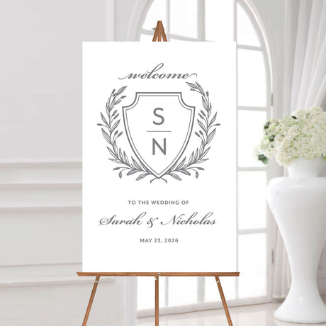 wedding welcome sign with a gray monogrammed crest, the names of the couple, and the wedding date