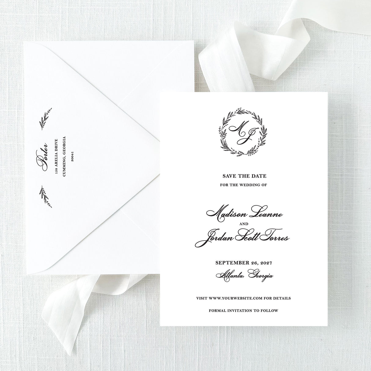 black and white wedding save the date card with wreath monogram and envelope with return addressing