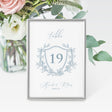 dusty blue crest wedding table number card featuring a crest with table number