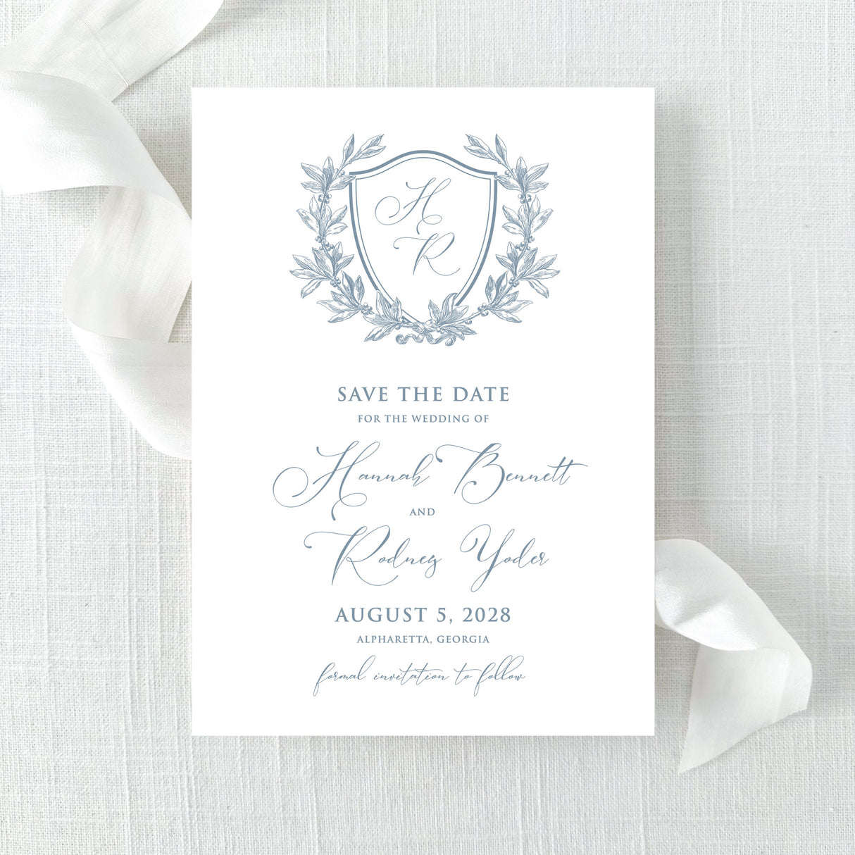 dusty blue wedding save the date card with floral wreath monogram design with calligraphy font
