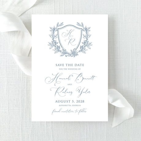 dusty blue wedding save the date card with floral wreath monogram design with calligraphy font