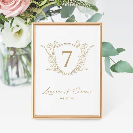 wedding table number featuring a gold crest design personalized with the names and wedding date
