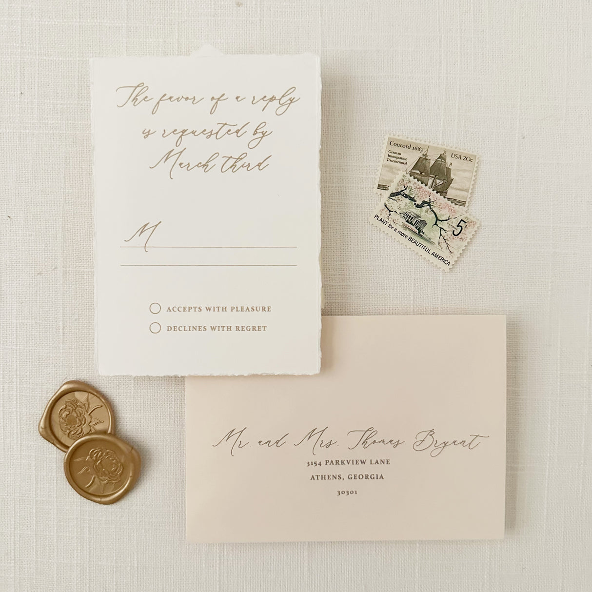 gold crest rsvp card with hand torn edges featuring flowing calligraphy script and barely there blush envelope with addressing