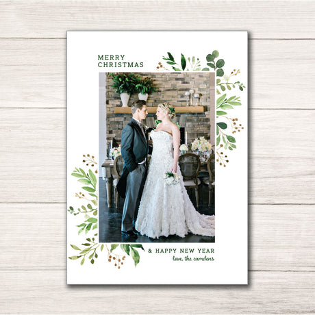 Christmas holiday photo card framed by a greenery design