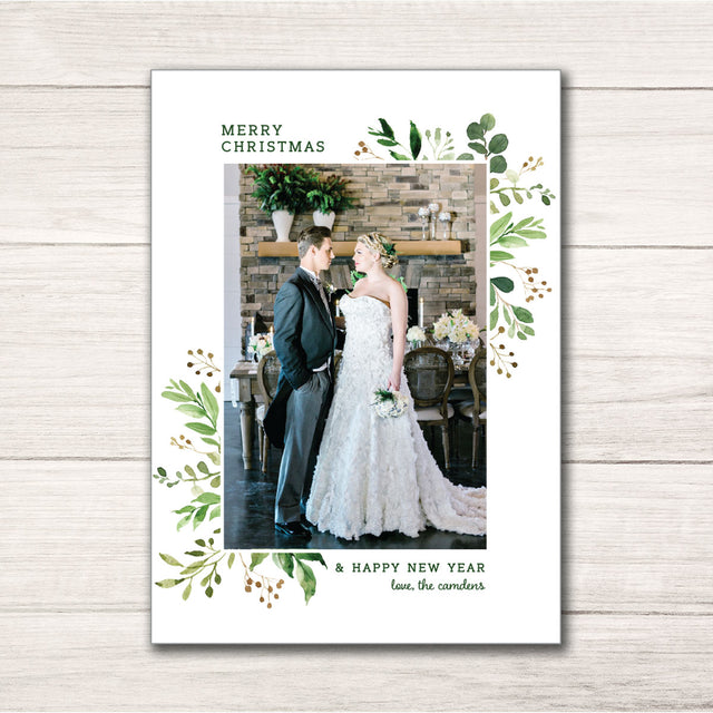 Christmas holiday photo card framed by a greenery design