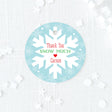 blue, red, and green favor tag with snowflake design on a blue background printed on white cardstock
