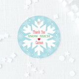 blue, red, and green favor tag with snowflake design on a blue background printed on white cardstock
