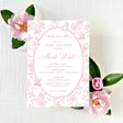 A pink baby shower invitation with floral pattern background, including roses and vintage baby designs