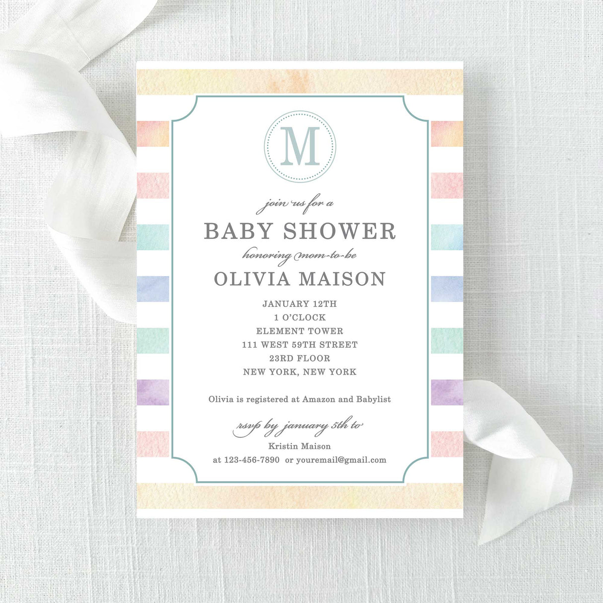Baby shower invitation with rainbow watercolor stripes and a monogram printed on cardstock.