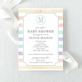 Baby shower invitation with rainbow watercolor stripes and a monogram printed on cardstock.
