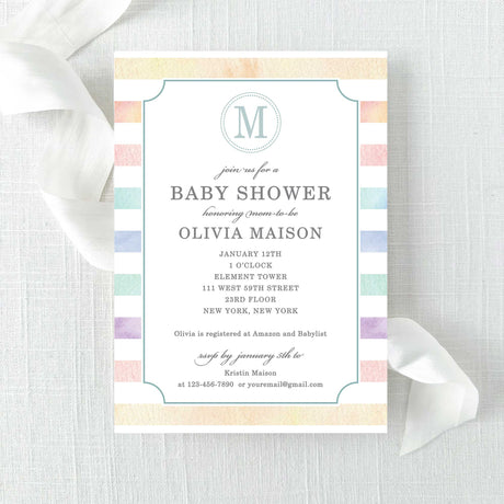 Baby shower invitation with rainbow watercolor stripes and a monogram printed on cardstock.