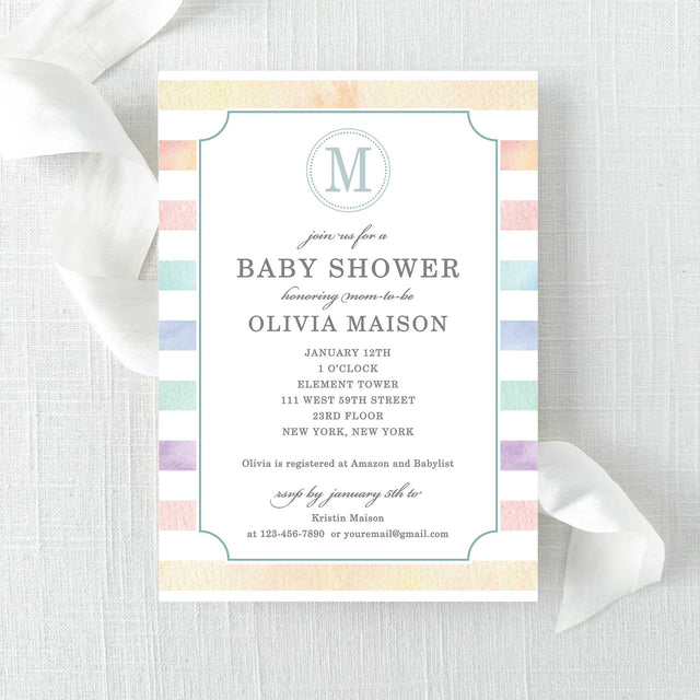 Baby shower invitation with rainbow watercolor stripes and a monogram printed on cardstock.