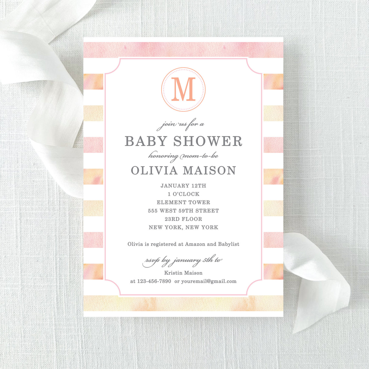 Baby shower invitation with pink and peach watercolor stripes and a monogram printed on cardstock.