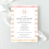 Baby shower invitation with pink and peach watercolor stripes and a monogram printed on cardstock.