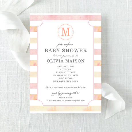Baby shower invitation with pink and peach watercolor stripes and a monogram printed on cardstock.