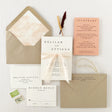 A set of modern boho wedding invitations with envelopes, an RSVP card, and a silk ribbon embellishment, featuring a peach-colored watercolor liner and natural khaki envelopes.