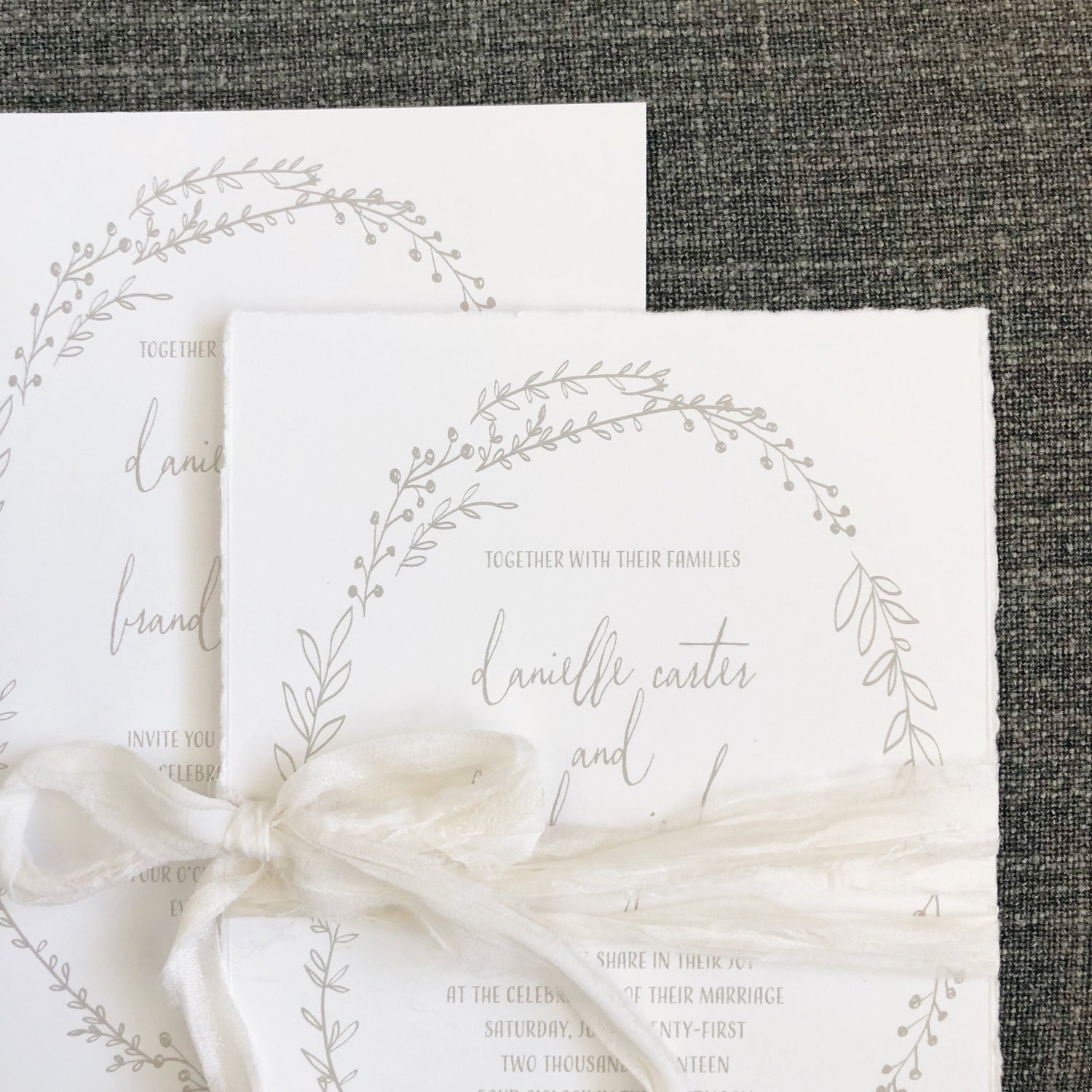 wedding invitation with minimal illustrated botanical border printed in grey ink or handtorn cotton cardstock with natural silk ribbon