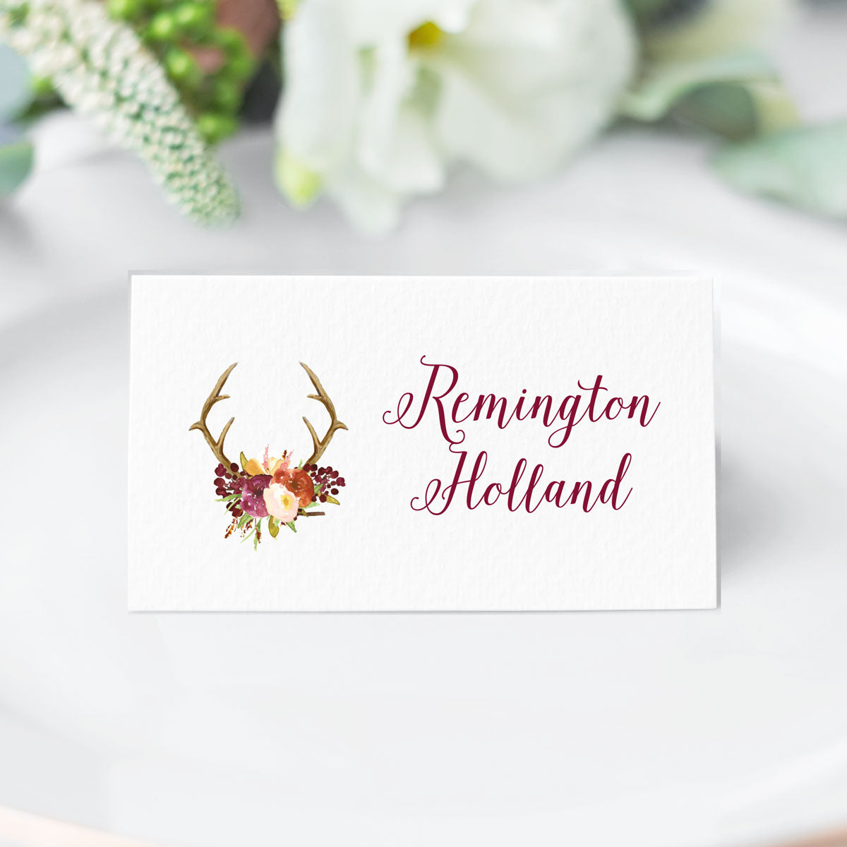 folded place card with rustic calligraphy font in burgundy with watercolor floral and antler design printed on cardstock