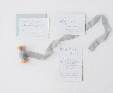 details cards and rsvp cards with handtorn  paper and hand lettered calligraphy script and dusty blue rsvp envelope