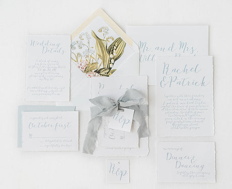 bespoke wedding invitation set with handtorn edges and dusty blue ink ribbon and envelope. Vintage painting envelope liner.